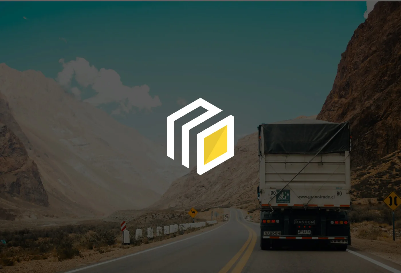 Marchio MAD Logistic & Solutions: cubo bianco con una faccia gialla, sulla foto di un camion